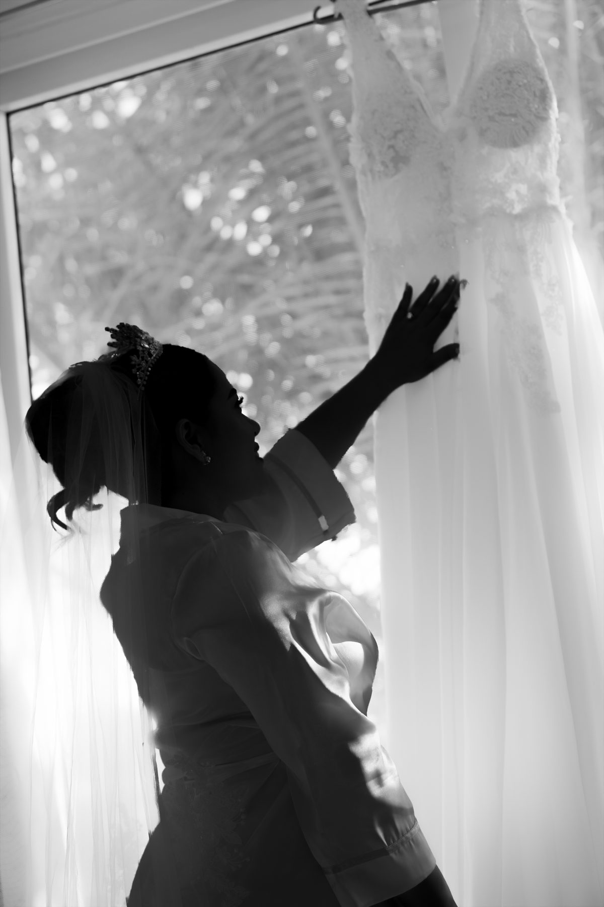 Novia en silueta junto a su vestido, retrato en blanco y negro